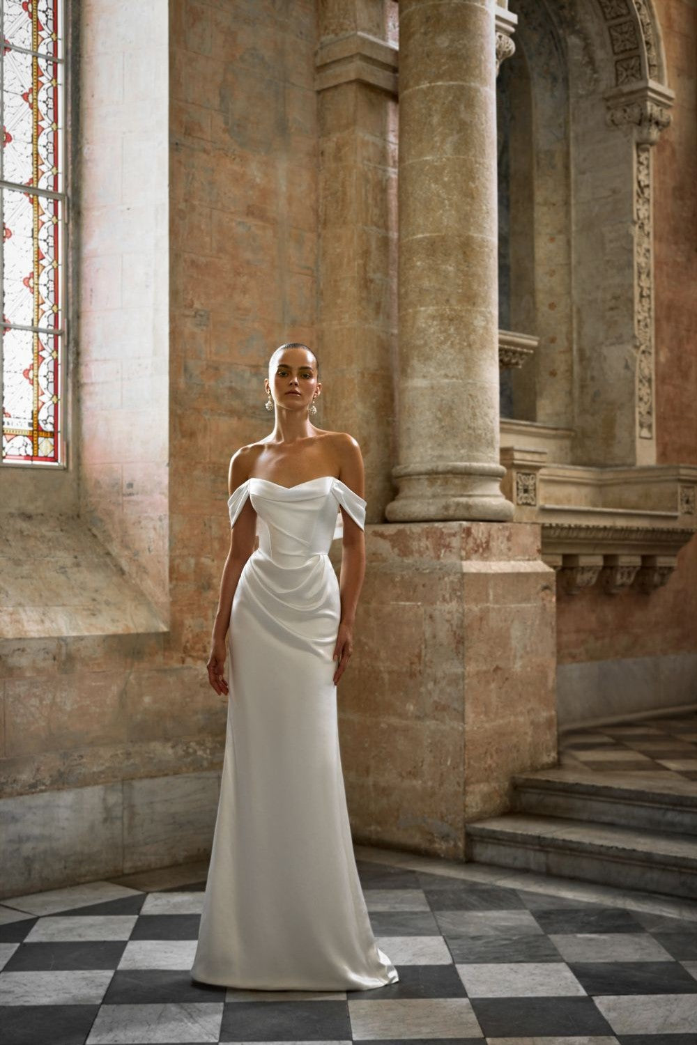 Minimalist Off-The-Shoulder Sheath Wedding Dress by Alon Livné for Kleinfeld — image 1 of 2